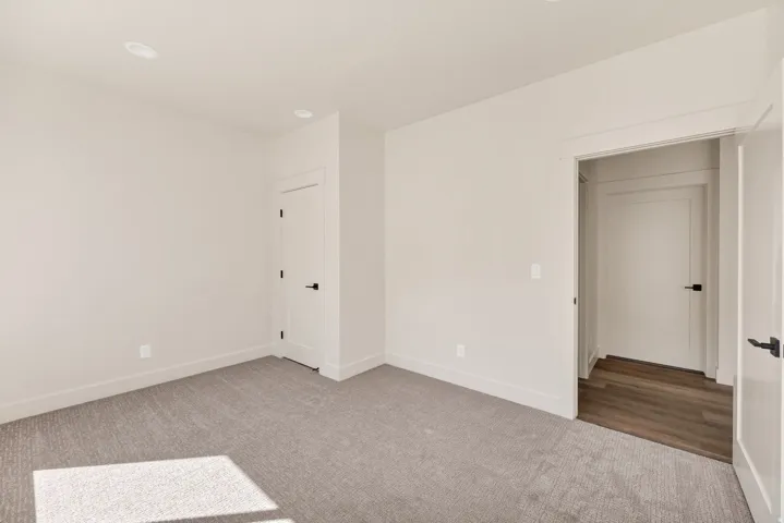 Recessed lighting, light gray carpeting, white walls, and white trim
