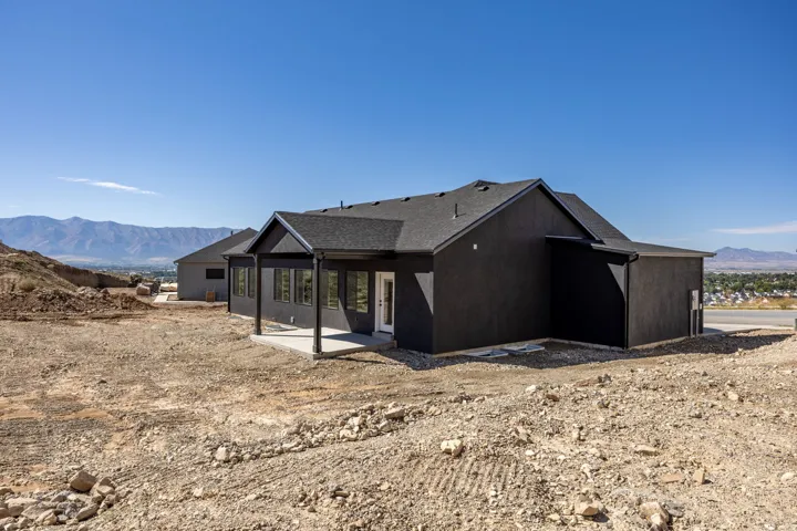Contemporary exterior with a covered patio, multiple windows, and a dark shingle roof
