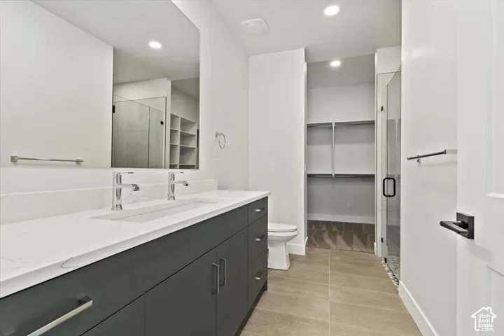 Dual vanity with white countertop, chrome fixtures, and dark cabinetry
