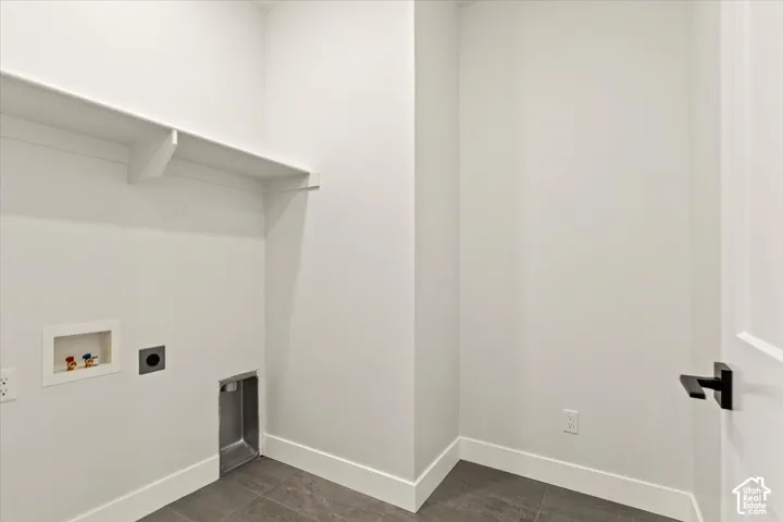 Utility area with built-in shelving, tile flooring, and white walls