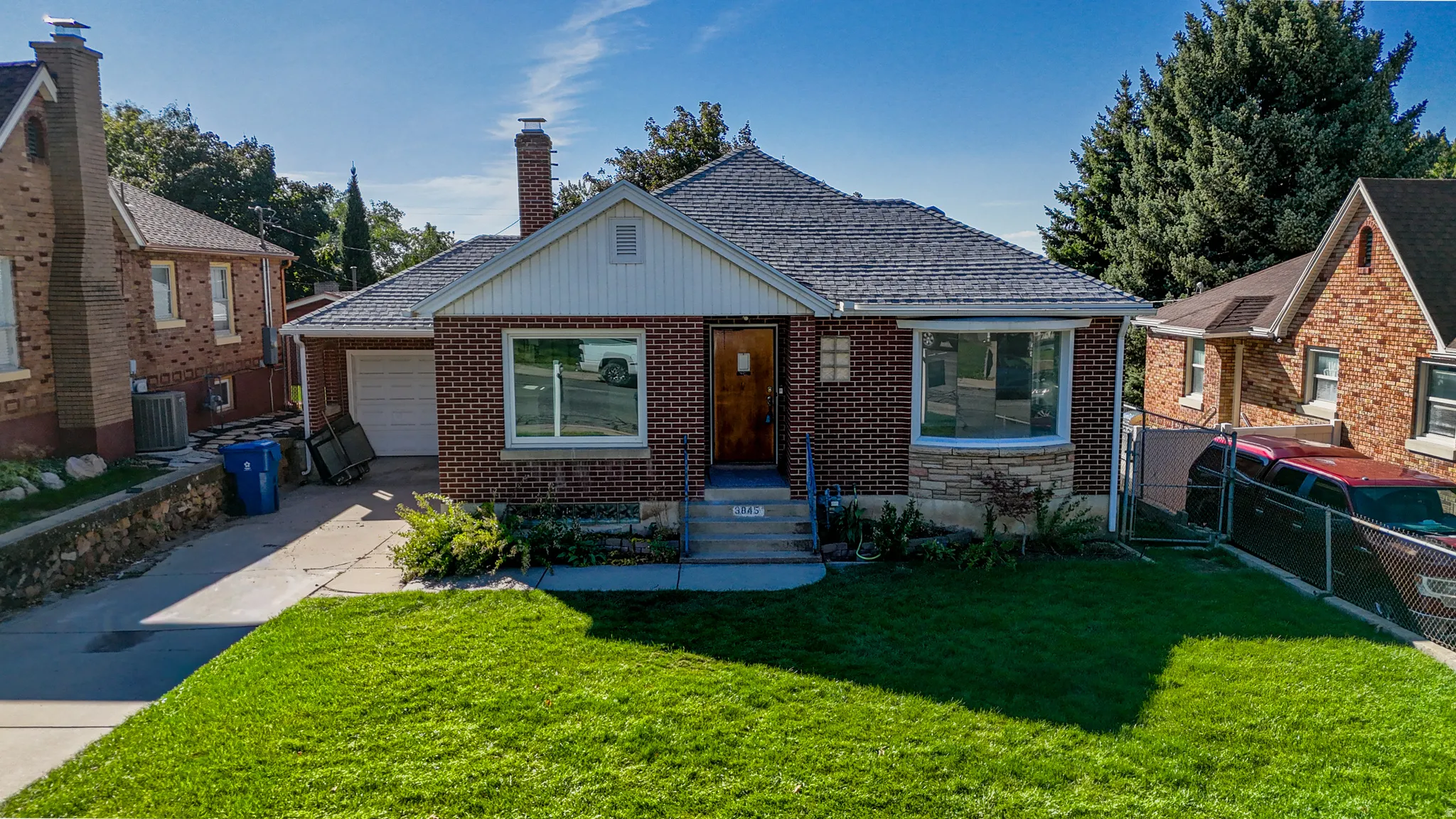 Brick exterior with stone accents, a single-car garage, and a bay window