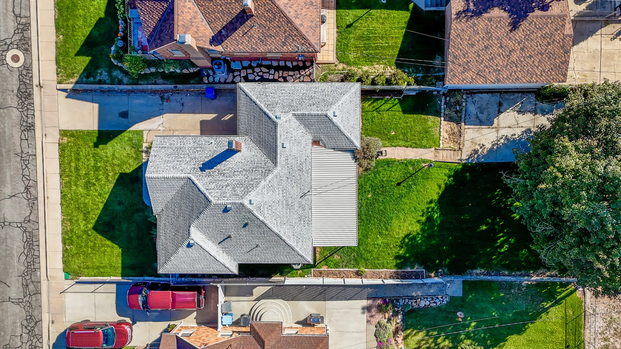 Expansive property featuring a gabled roofline, multiple grass lawns, and concrete driveways