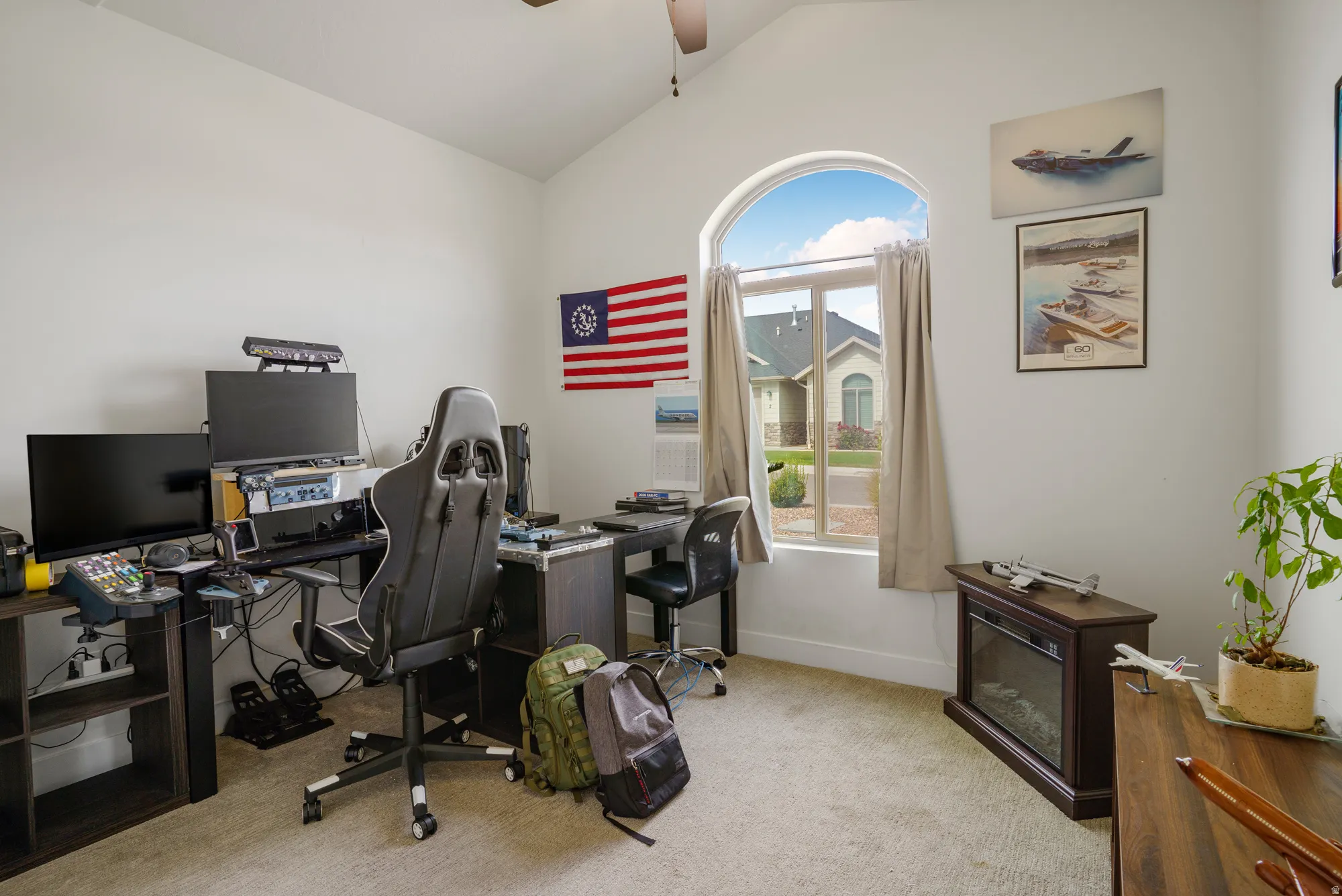 Arched window, vaulted ceiling, and carpeted flooring