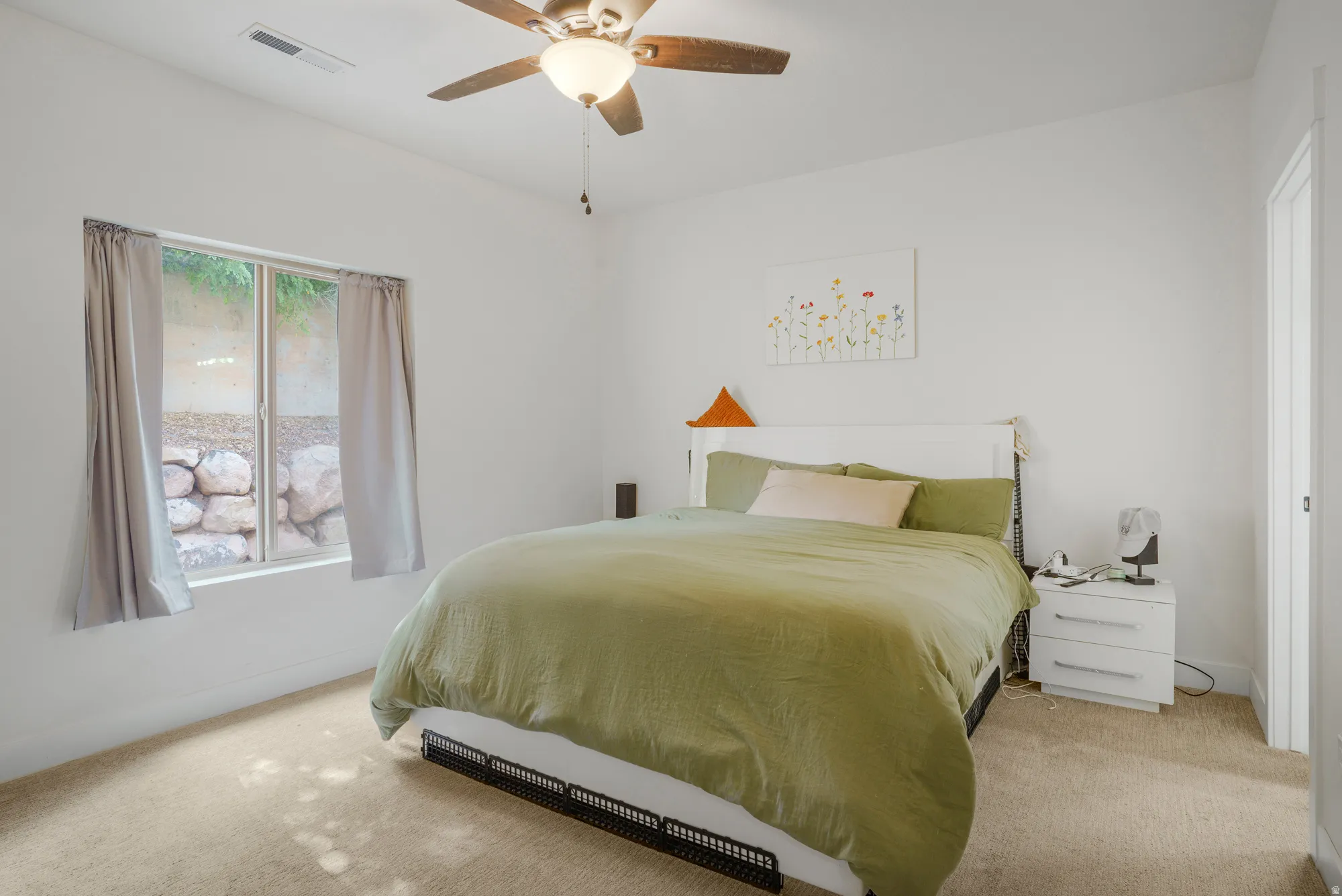 Carpeted flooring, white walls, and a ceiling fan with integrated lighting