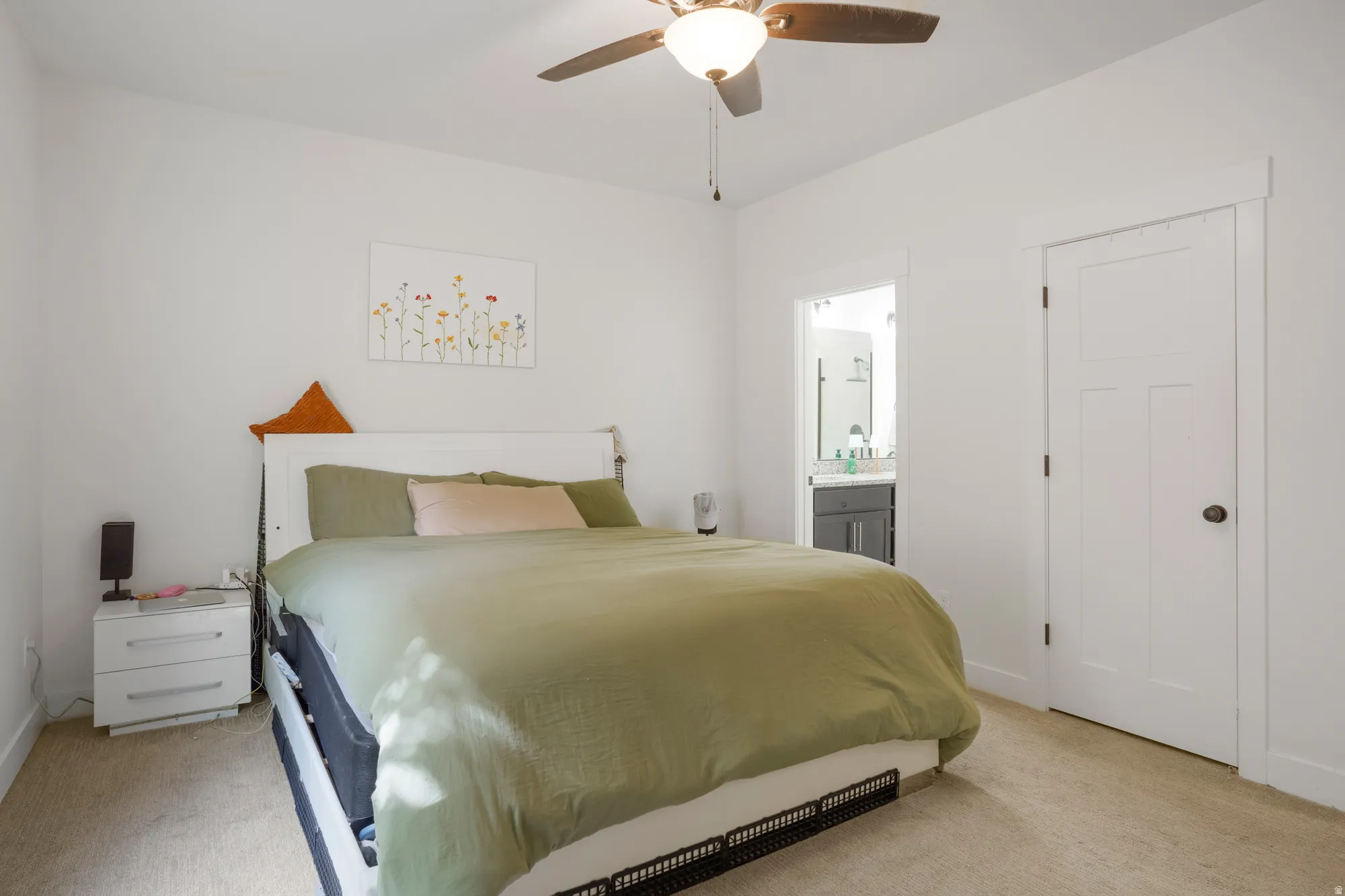 Carpeted bedroom with a ceiling fan light fixture