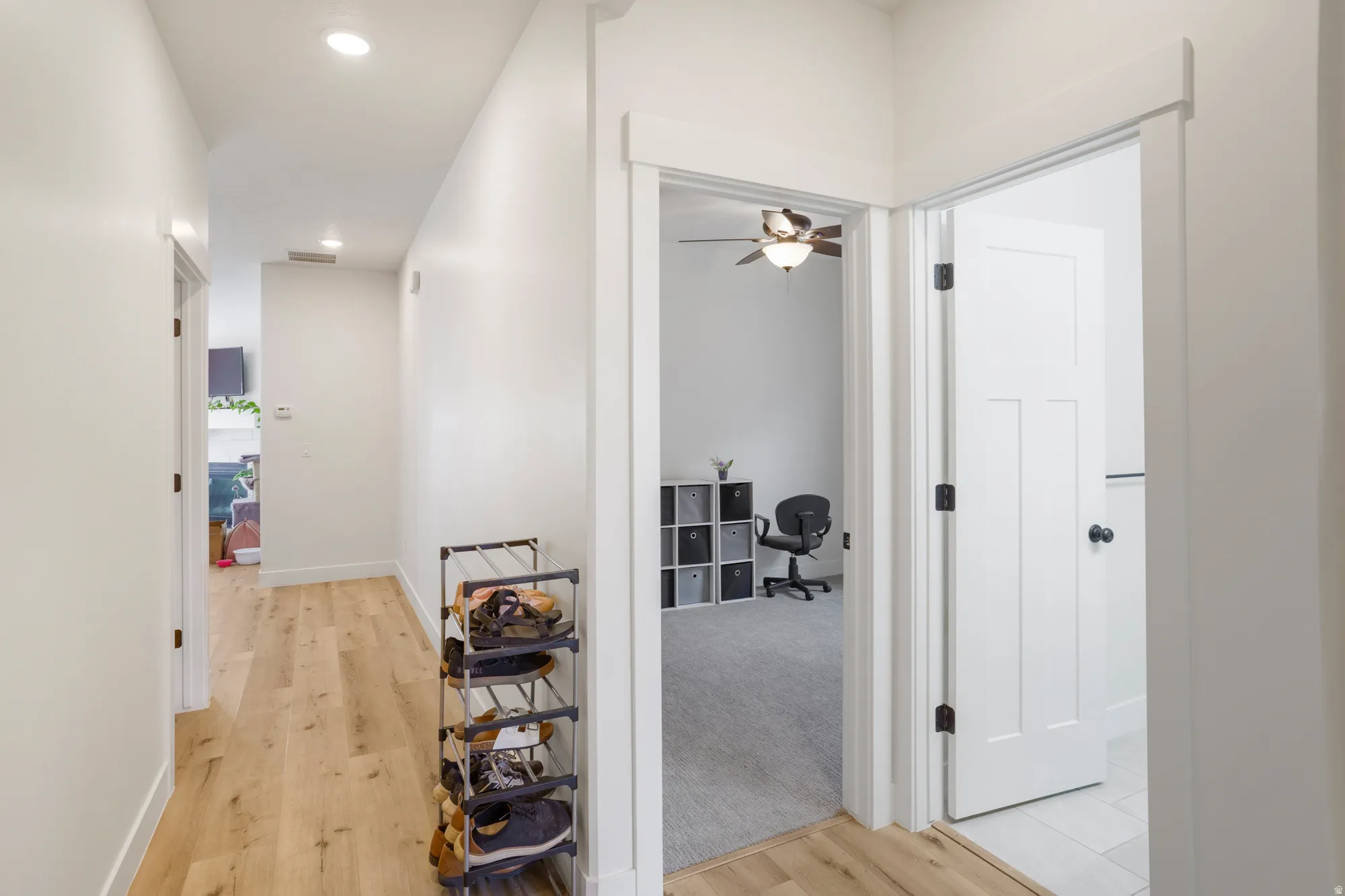 Hallway featuring wood-finish flooring, recessed lighting, and white trim
