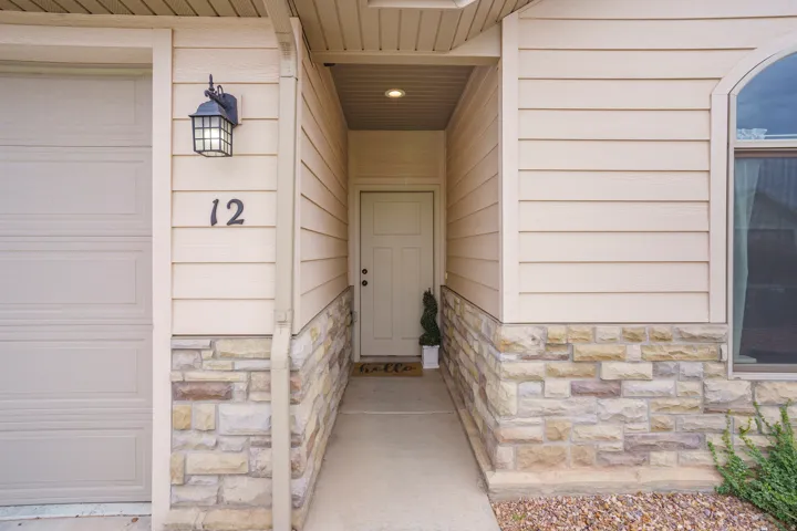 Entryway featuring stone veneer and horizontal siding