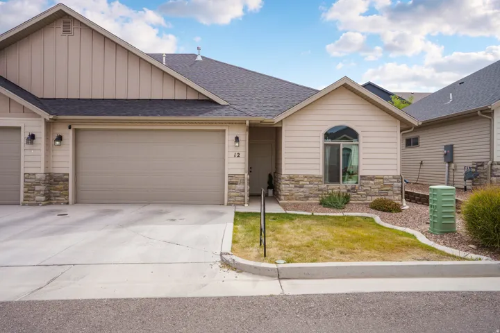 Exterior featuring stone accents, horizontal siding, an arched window, a two-car garage, and a concrete driveway