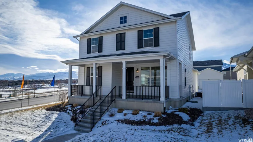 Two-story residence featuring white siding, a covered front porch, and black window shutters