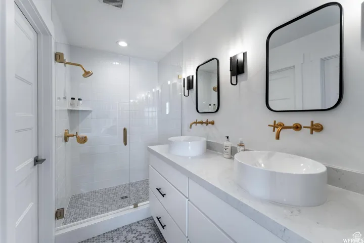 Dual vanity with vessel sinks and wall-mounted brass fixtures