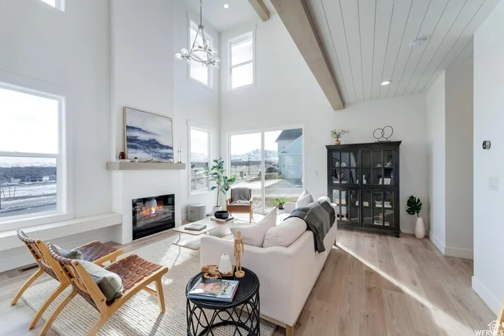 High ceilings with exposed beams, ample natural light, a built-in fireplace, and sliding glass doors