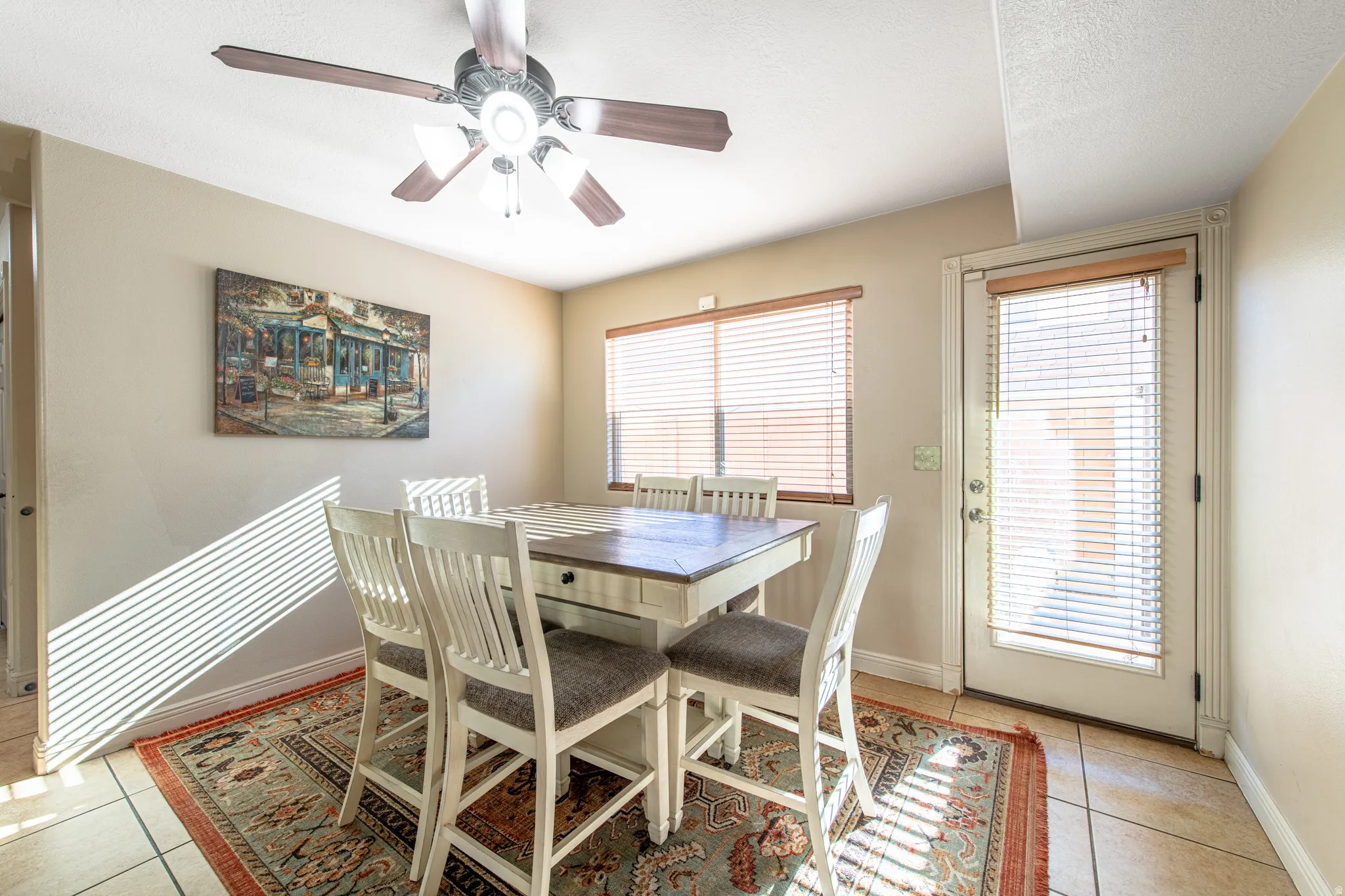 Ceiling fan with integrated lighting, window with blinds, door with integrated blinds, tile flooring, and neutral wall tones