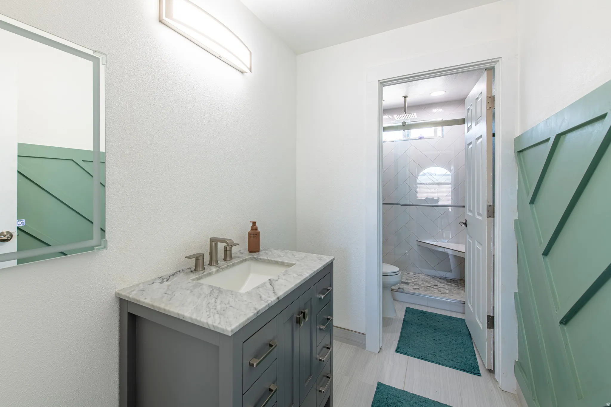 Contemporary vanity with a rectangular undermount sink, stone countertop, and brushed nickel faucet