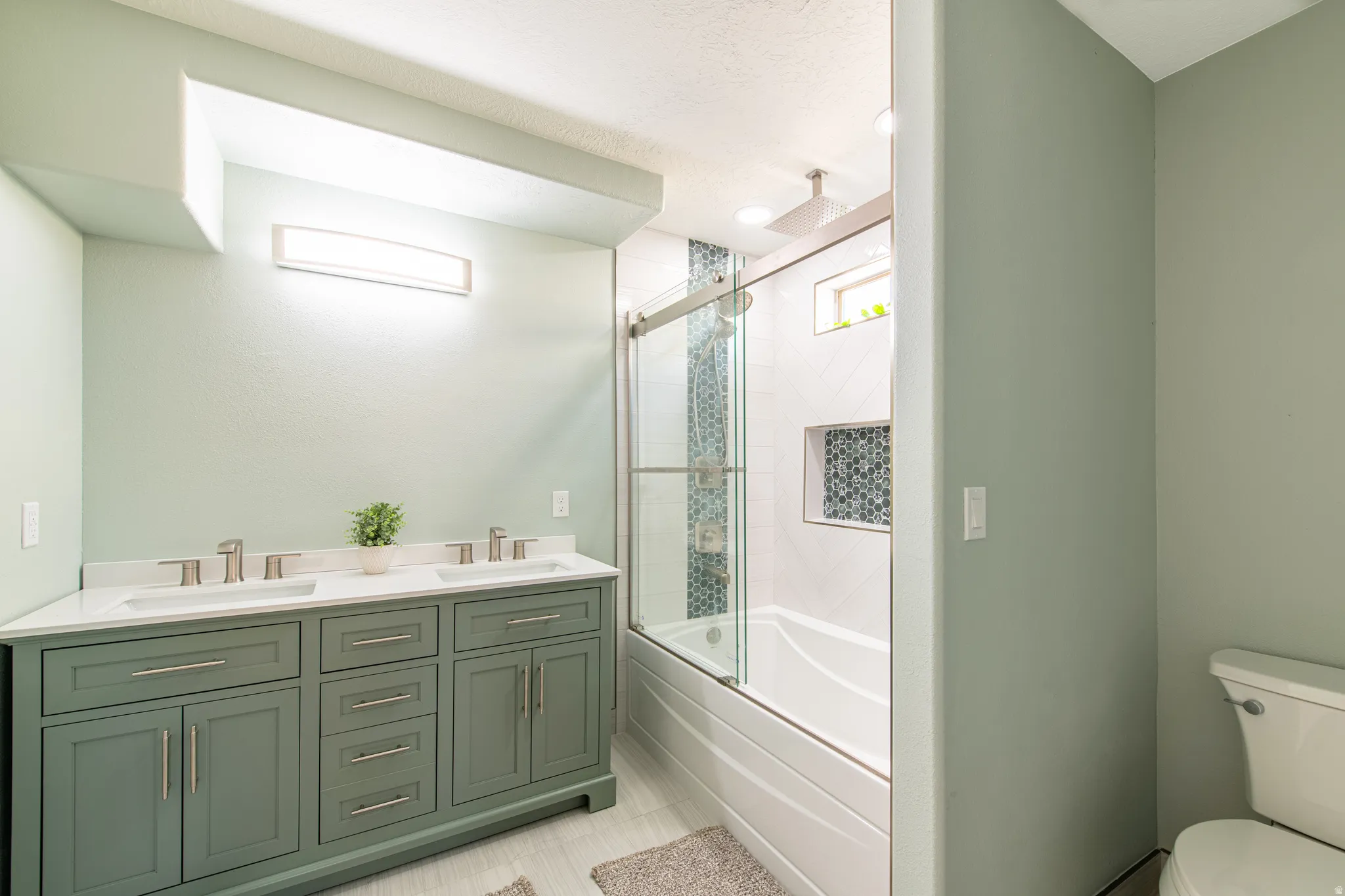 Dual vanity with light green cabinetry and white countertops