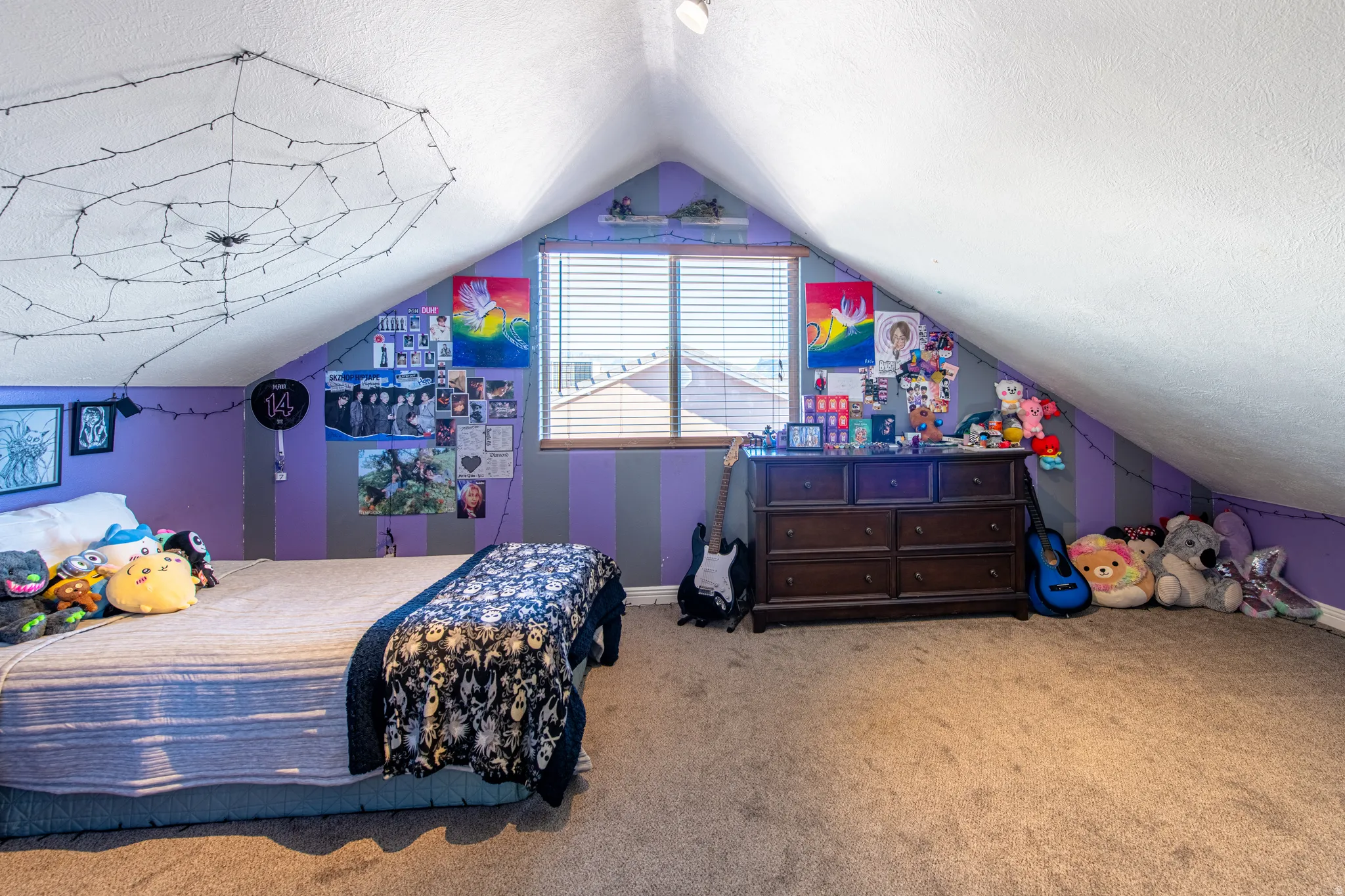Attic space featuring sloped ceilings, a window with blinds, and carpet flooring