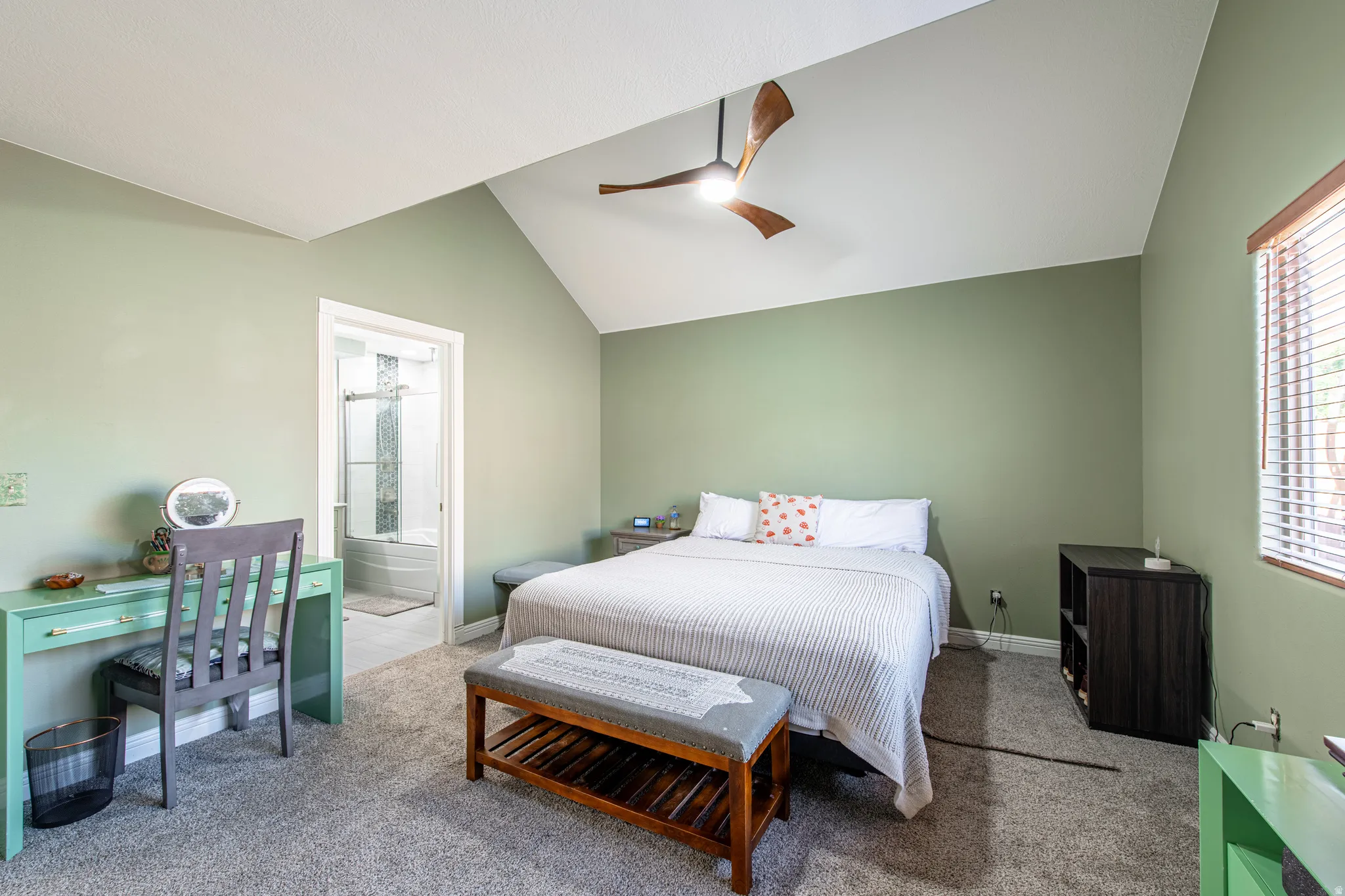 Vaulted ceiling with a wood-finish ceiling fan, carpeted flooring, and a window with blinds