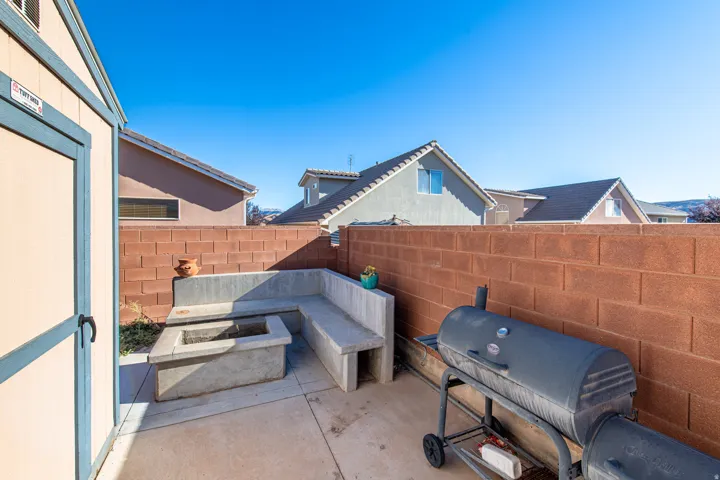 Paved patio featuring a built-in concrete bench and an integrated fire pit