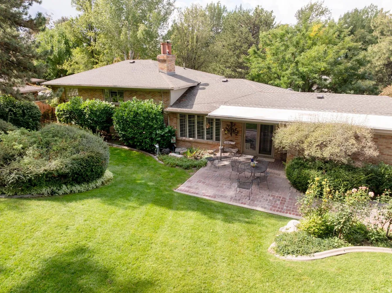 Brick exterior with a shingle roof and a brick chimney