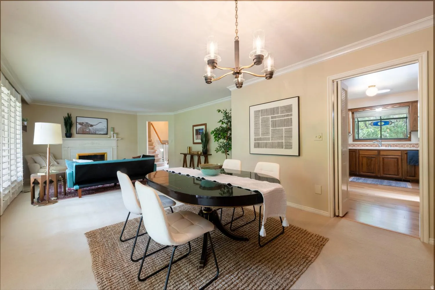 Recessed fireplace with mantel, window with plantation shutters, crown molding, and a traditional chandelier