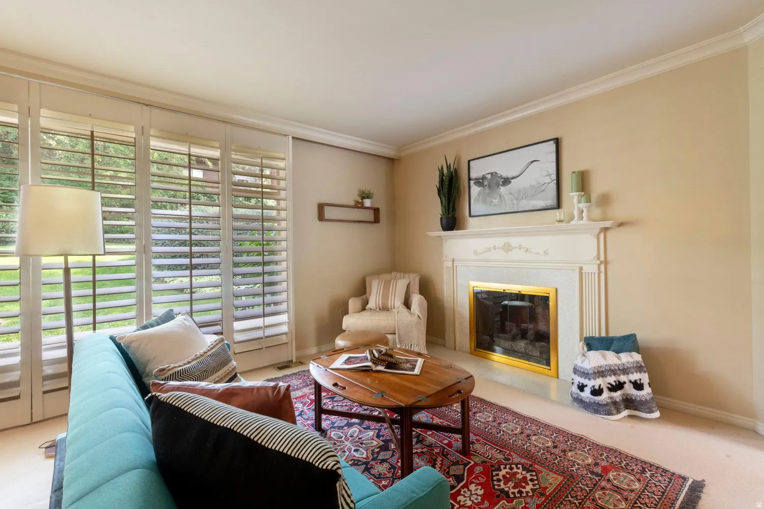 White plantation shutters and crown molding enhance the living area