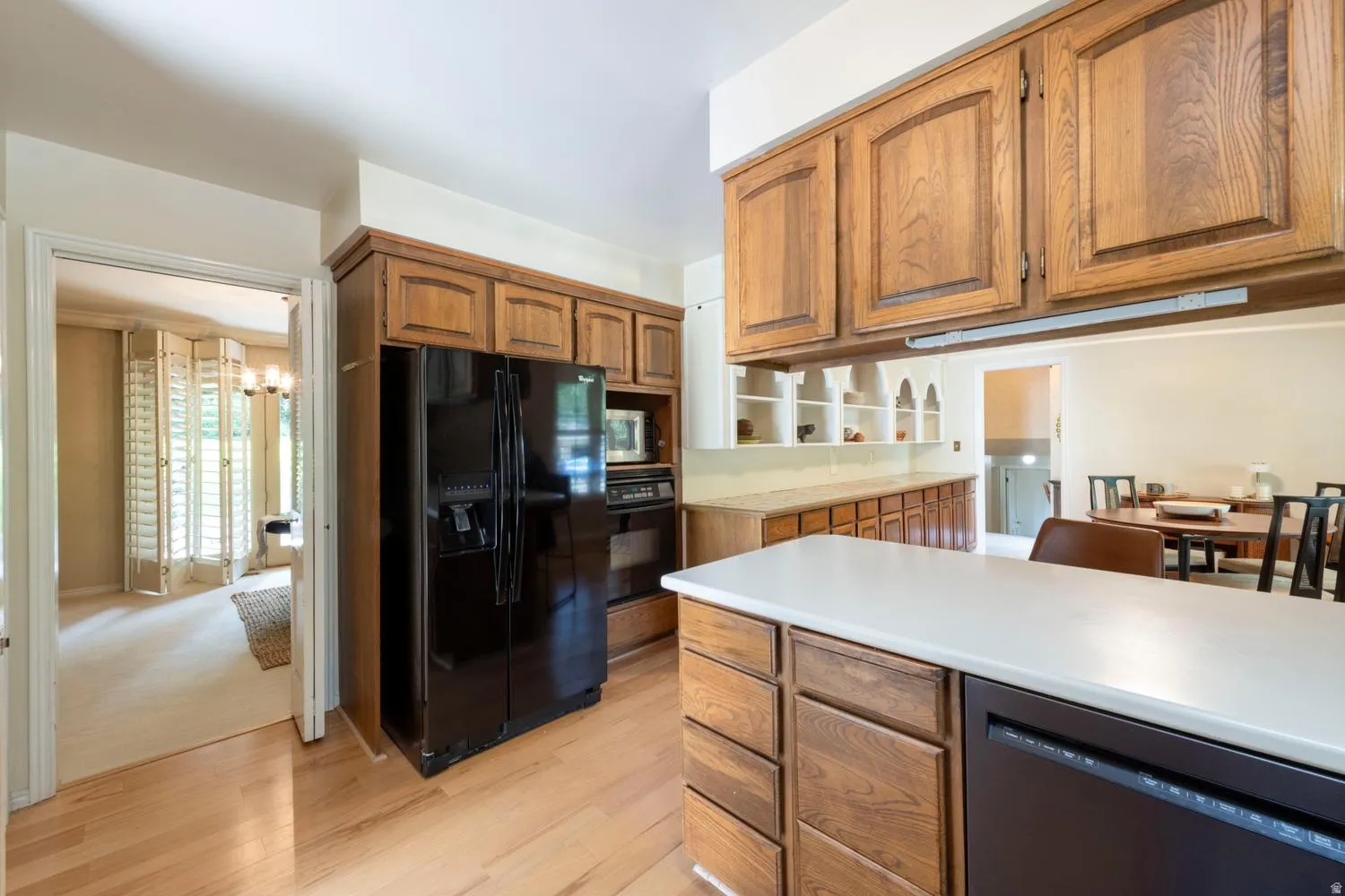 Wood-finish flooring with perimeter cabinetry and a built-in refrigerator