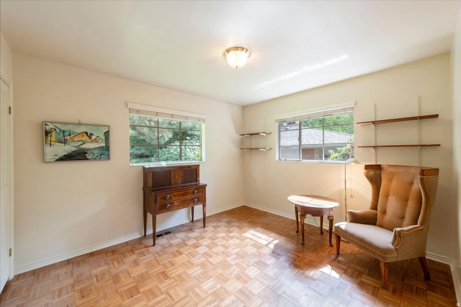 Parquet wood flooring, a flush-mount ceiling light fixture, and two windows with blinds