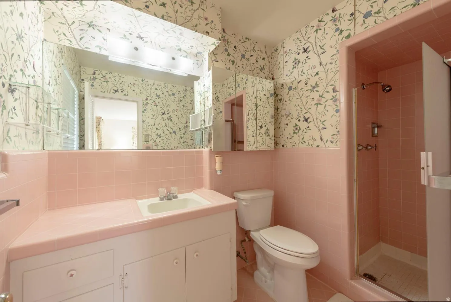 Pink tiled shower with glass enclosure