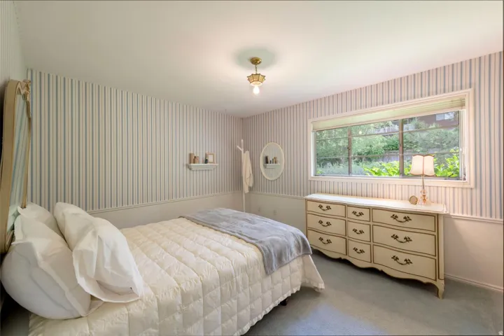 Striped wallpaper, wainscoting, and a ceiling-mounted light fixture