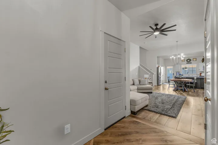 Light wood-finish flooring throughout, modern paneled doors, and a ceiling fan with integrated lighting