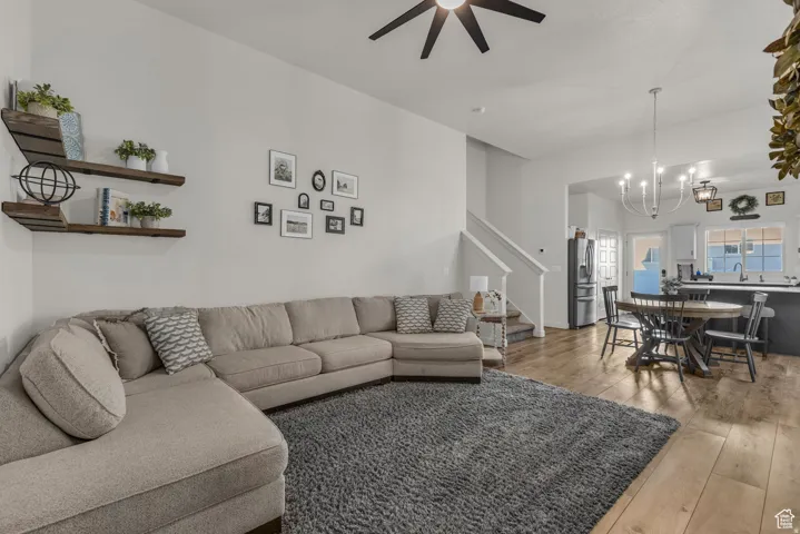 Wood-finish flooring throughout, bright white walls, and a recessed ceiling fan light fixture