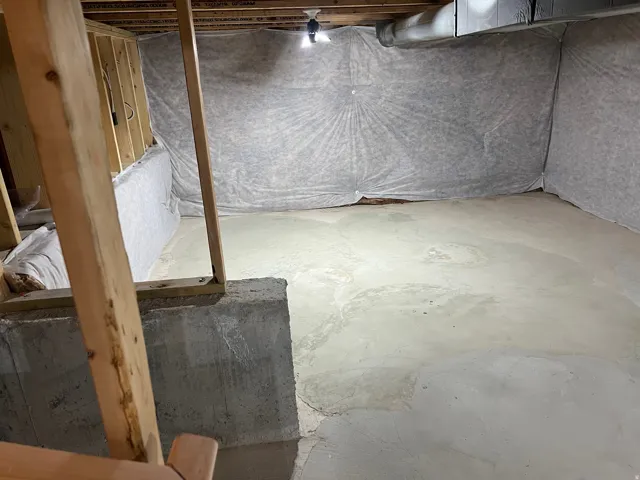 Unfinished concrete floor, exposed wood framing, and insulated foundation walls