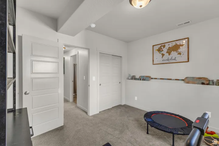 Recessed ceiling lighting, textured carpeting, contemporary panel doors, and a built-in wall shelf