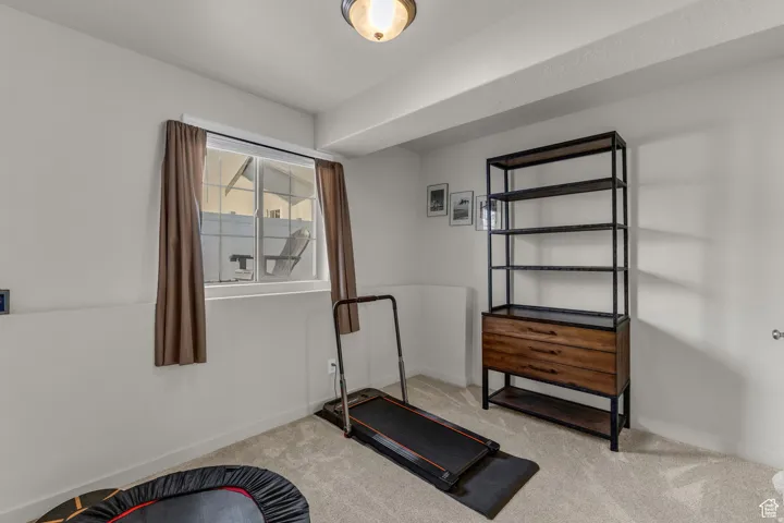 Recessed ceiling light fixture, white walls, and neutral carpet flooring