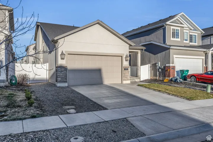 Stucco exterior with stone accents and an attached garage
