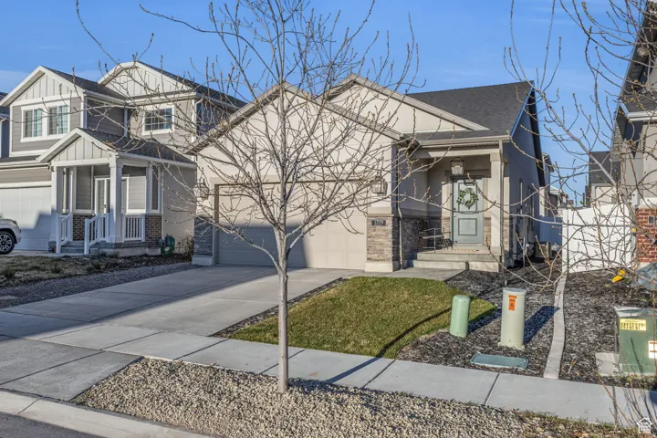 Single-family residence featuring a two-car garage, covered porch entry, and a combination of siding and stone veneer exterior finishes