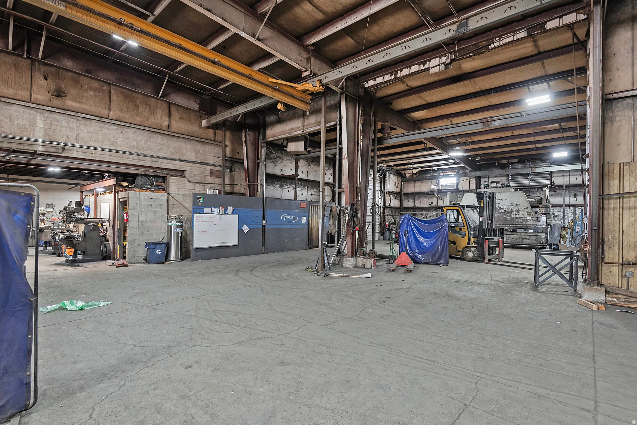 Expansive concrete floor space with high industrial ceilings and exposed structural beams