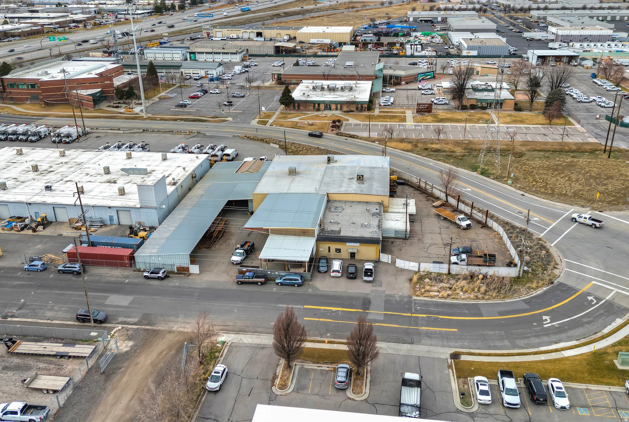 Industrial property featuring multiple structures, extensive paved areas, and direct road access