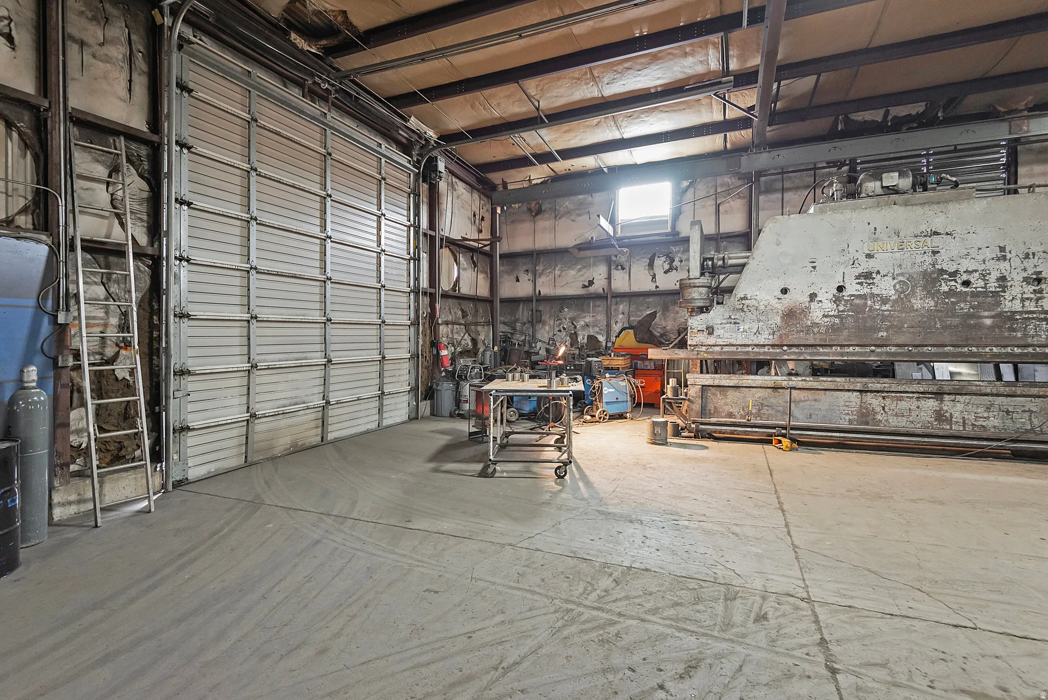 Industrial space featuring a large roll-up door and concrete flooring