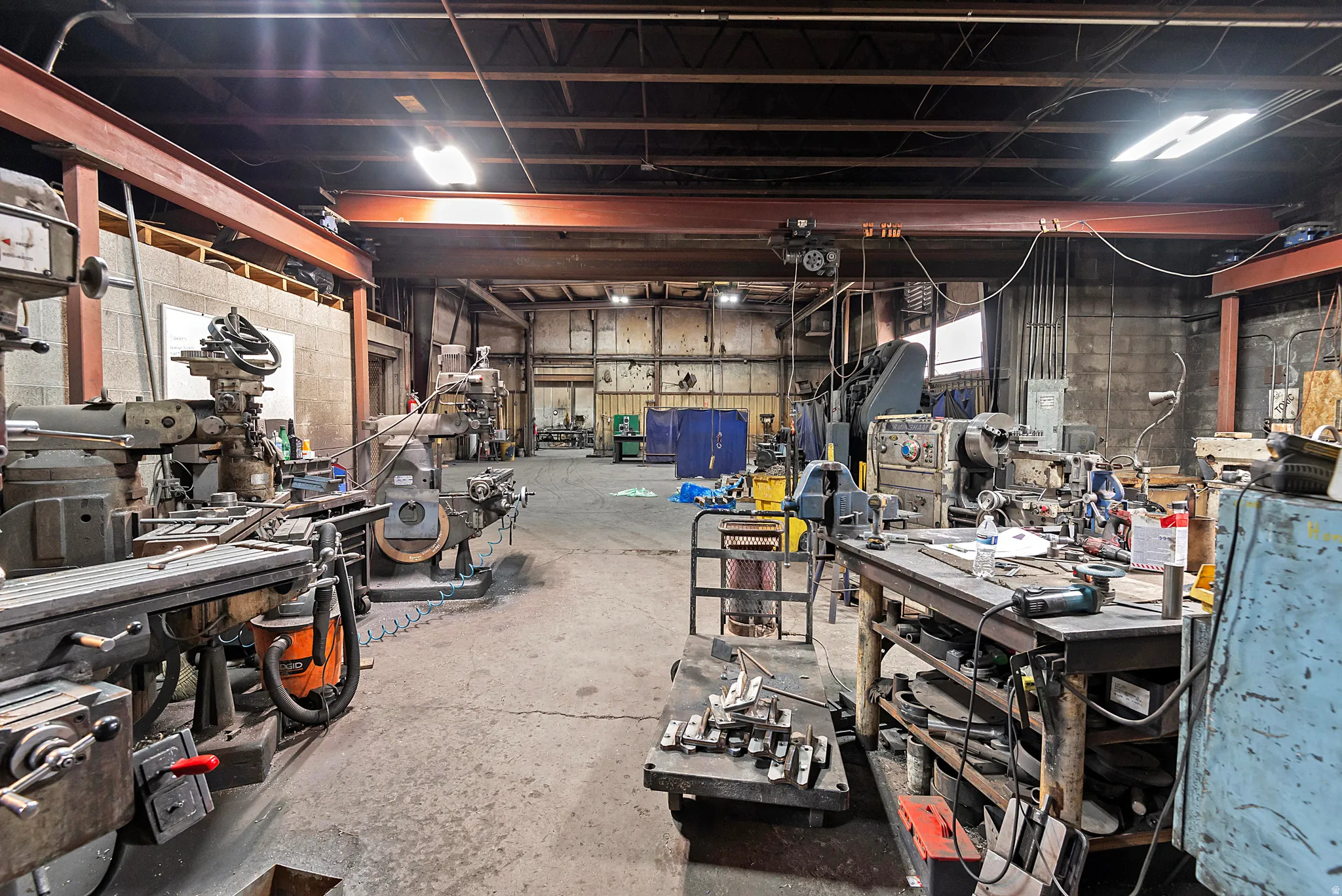 Industrial-style interior featuring exposed structural beams, concrete flooring, and ample overhead lighting