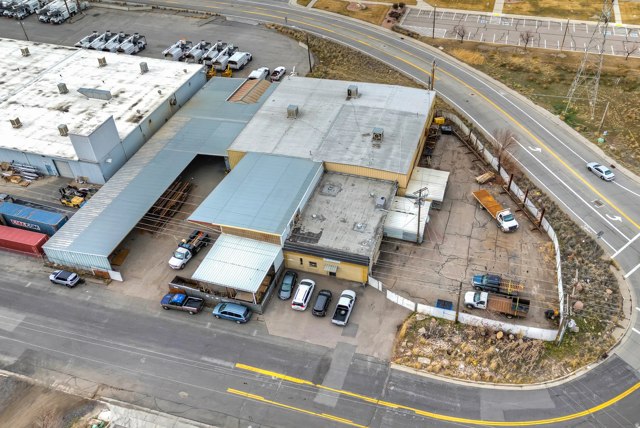 Industrial building with multiple rooflines, a large paved lot, and direct road access