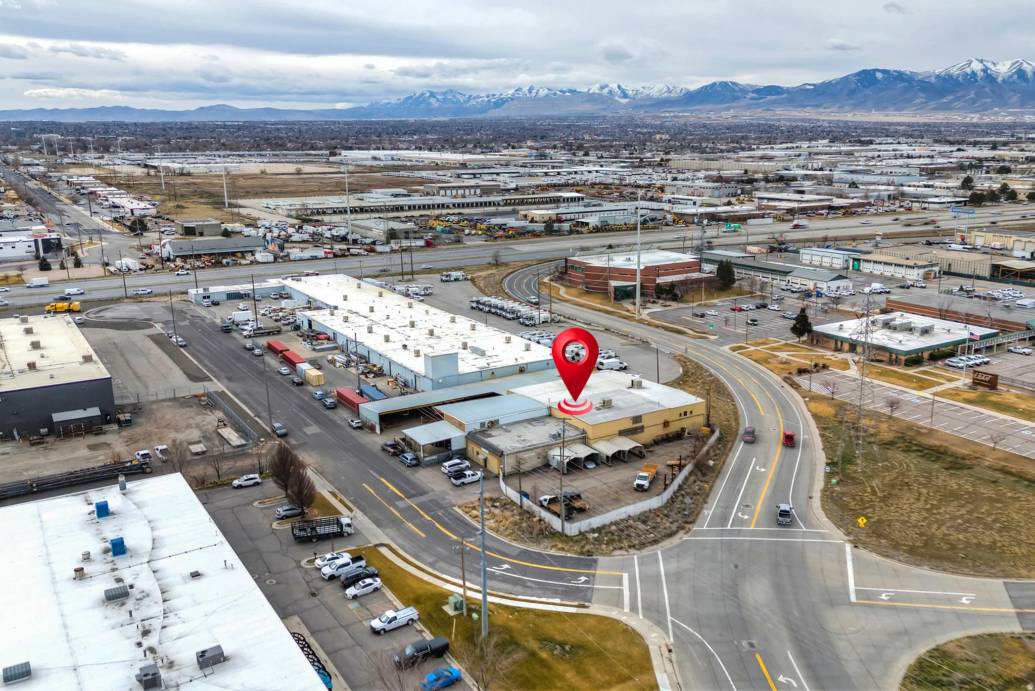Industrial building with multiple bays, adjacent paved parking, and direct road access