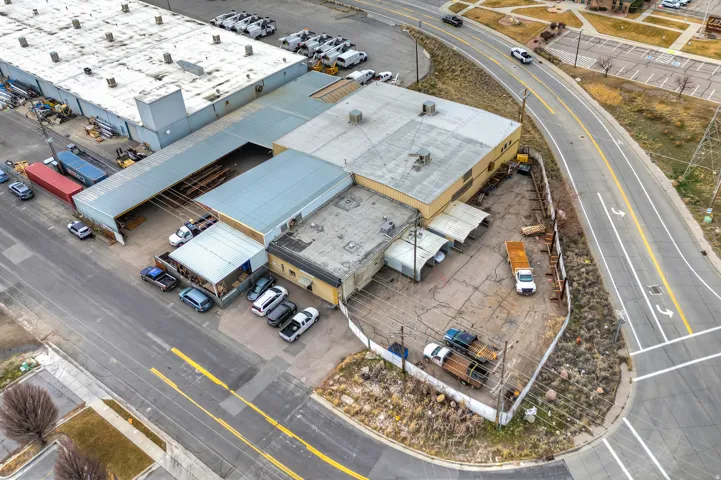 Industrial property featuring multiple buildings with metal roofs and extensive paved parking areas