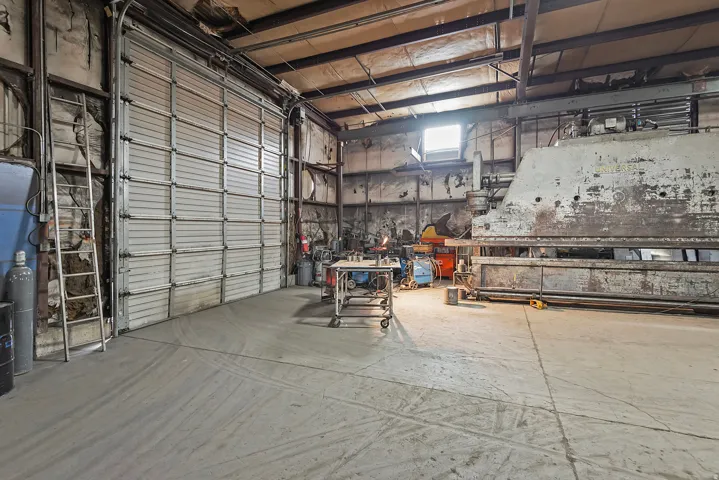 Industrial space featuring a large roll-up door and concrete flooring