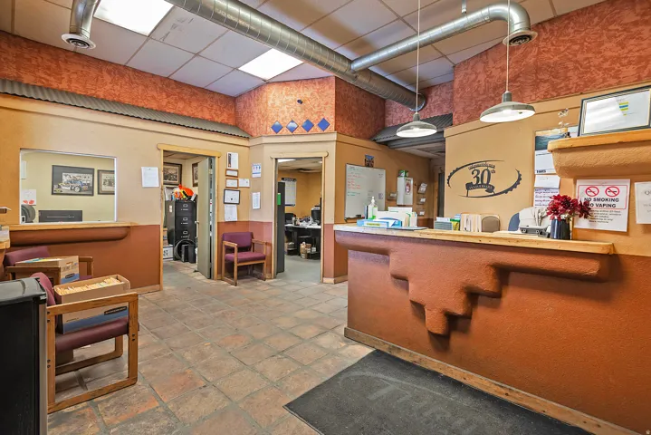 Reception area featuring a built-in counter, terracotta-style flooring, and exposed ductwork