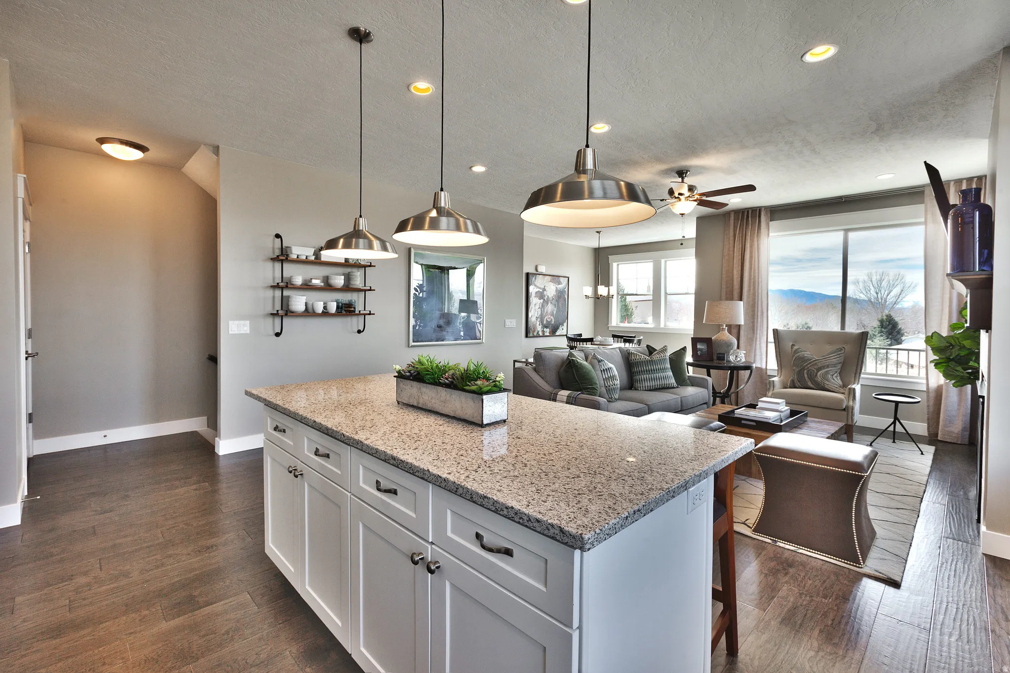 Kitchen island with a light-toned granite countertop and white cabinetry