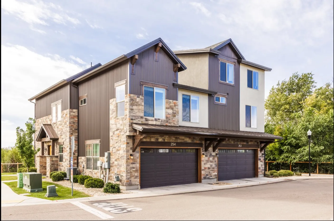 Multi-level exterior featuring stone accents, vertical siding, and multiple windows