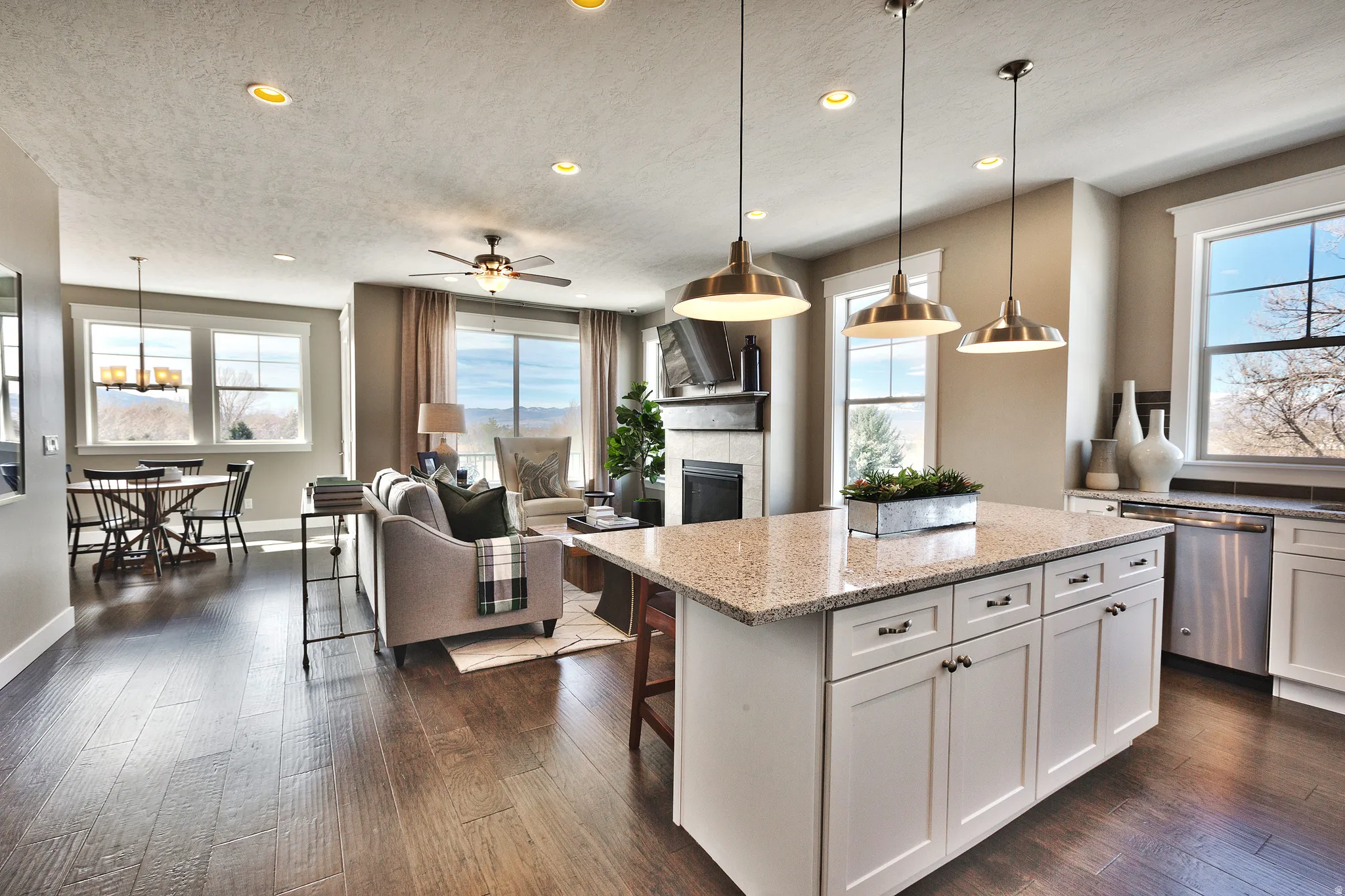 Expansive wood-finish flooring, recessed lighting, and a kitchen island with a light-toned countertop