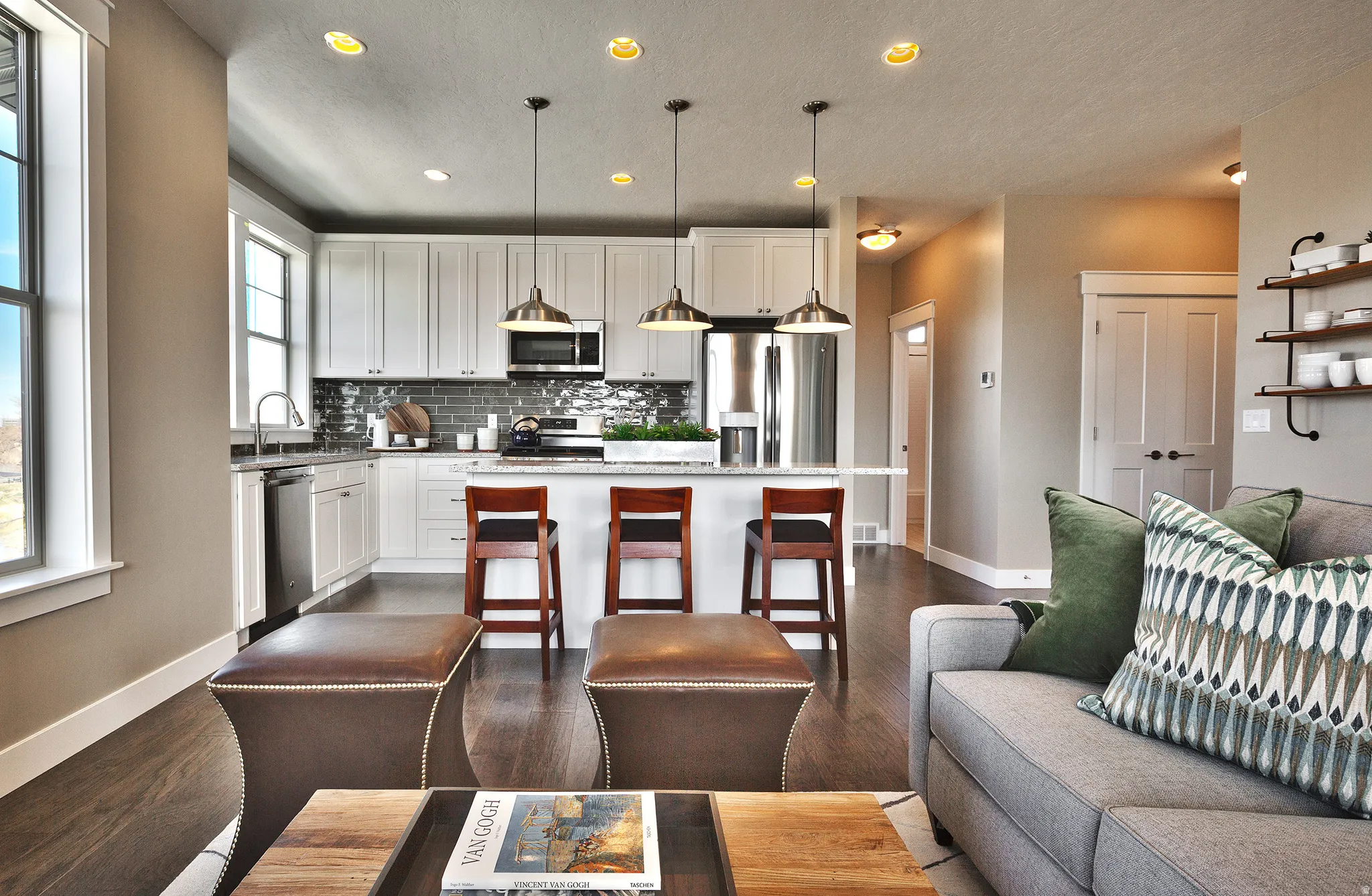 Open concept living area featuring wood-finish flooring, recessed lighting, and a kitchen island with pendant lighting