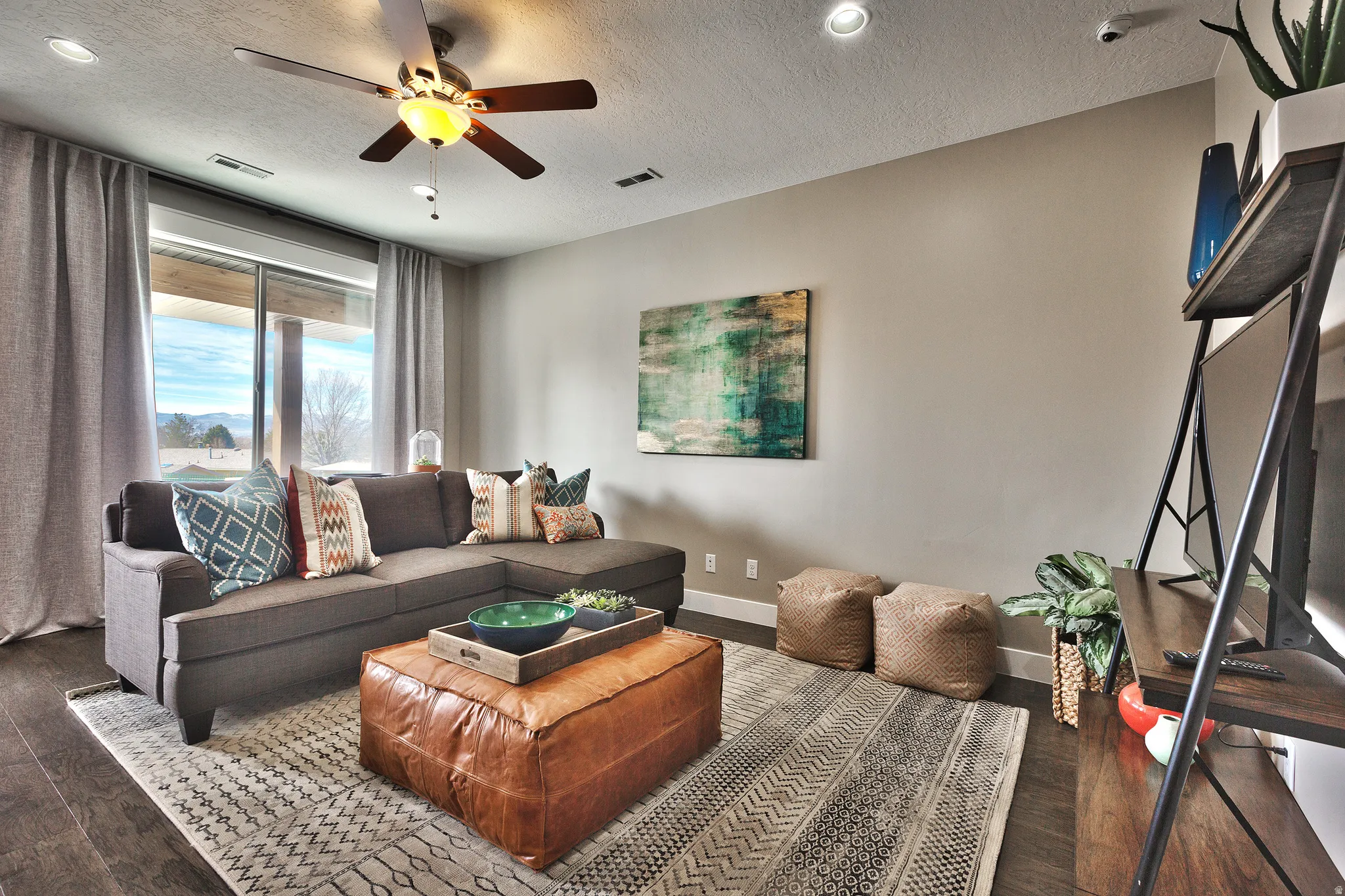 Recessed lighting, ceiling fan, wood-finish flooring, sliding glass door, and a built-in shelf unit