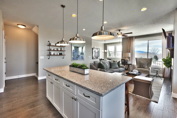 Kitchen island with a light-toned granite countertop and white cabinetry